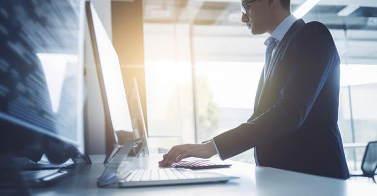 a man in a suit typing on a computer